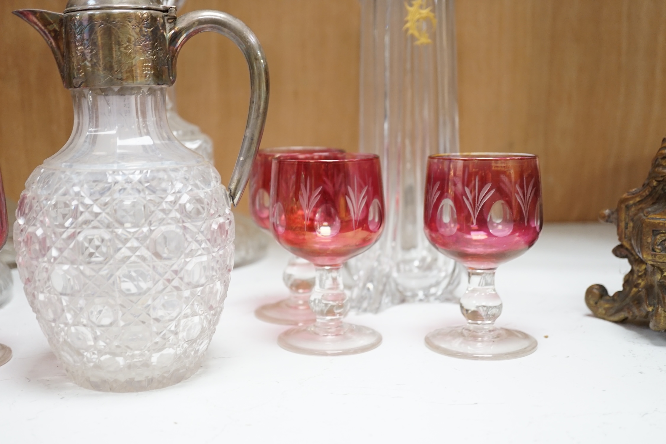 Two pairs of cut glass ships decanters, a square decanter, a ewer and a tall Scottish decanter and six cranberry glasses, tallest 43cm high